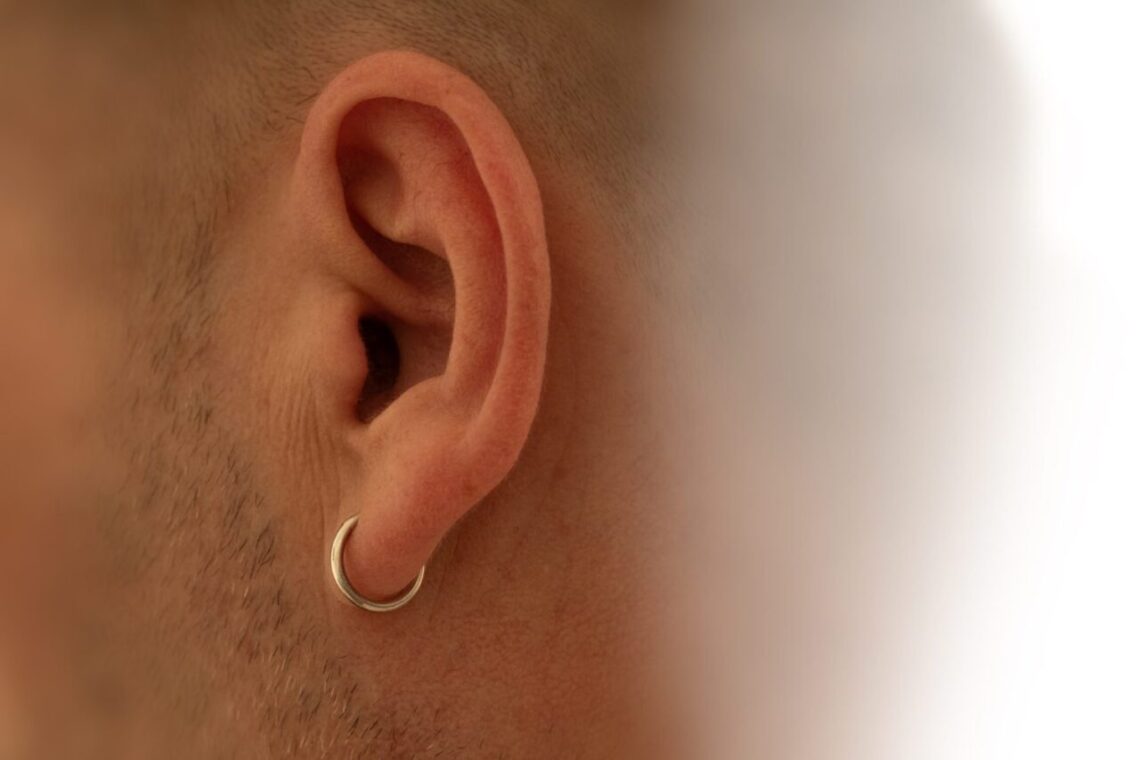 Gros plan sur une oreille portant un piercing, pour illustrer la douleur selon la zone percée.